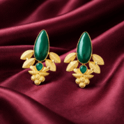 Elegant gold earrings on silk fabric