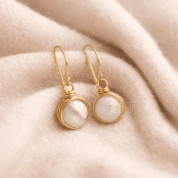 Elegant gold earrings on soft fabric