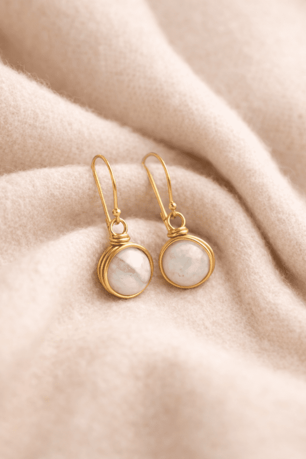 Elegant gold earrings on soft fabric