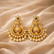 Golden jhumka earrings on silk fabric