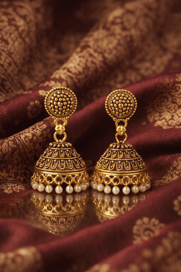 Traditional gold jhumka earrings on silk
